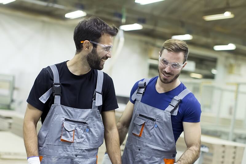 Two Douglas factory workers laughing on the job