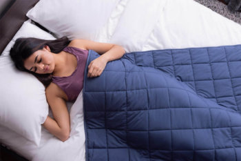 Woman sleeping peacefully with Classic Weighted Blanket draped over her body