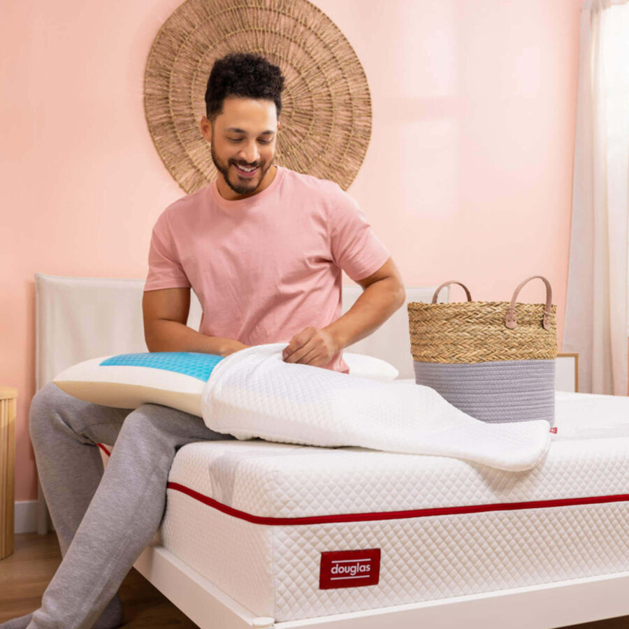 Man removing a Douglas Cooling Gel Pillow from its machine-washable cover