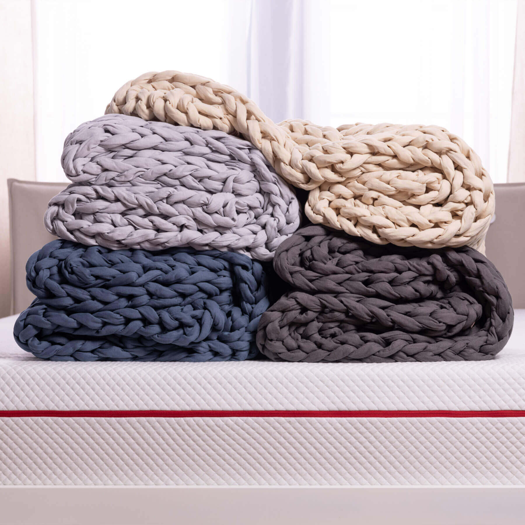 DB-BWB-Carousel-Blue-v2.0-6 Stack of four neatly folded Douglas Hand Knit Weighted Blankets showing each of the four available colours