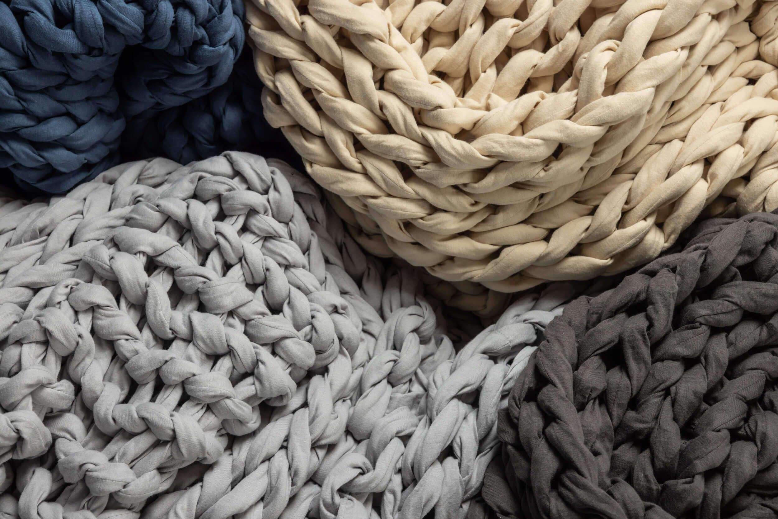Close up of the four available Douglas Hand Knit Weighted Blanket colours: Dark Grey, Light Grey, Navy, and Cream