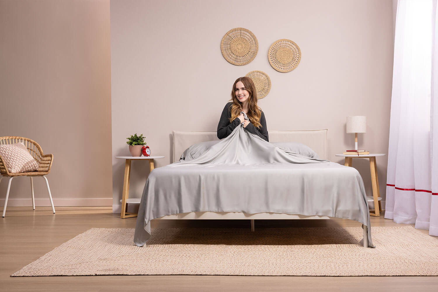 Woman smiling and touching her set of Douglas Bamboo Sheets