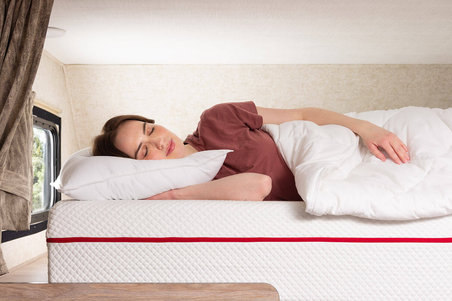 Woman sleeping inside an RV on a Douglas mattress