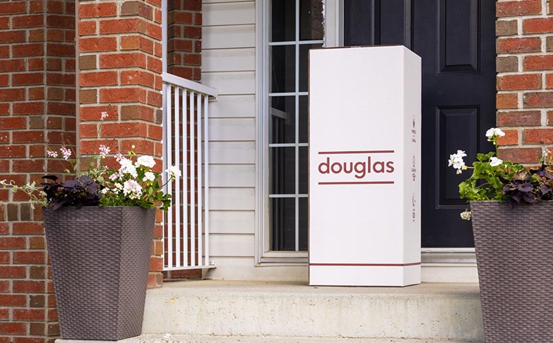 Douglas mattress shipping box sitting at the front door of a home