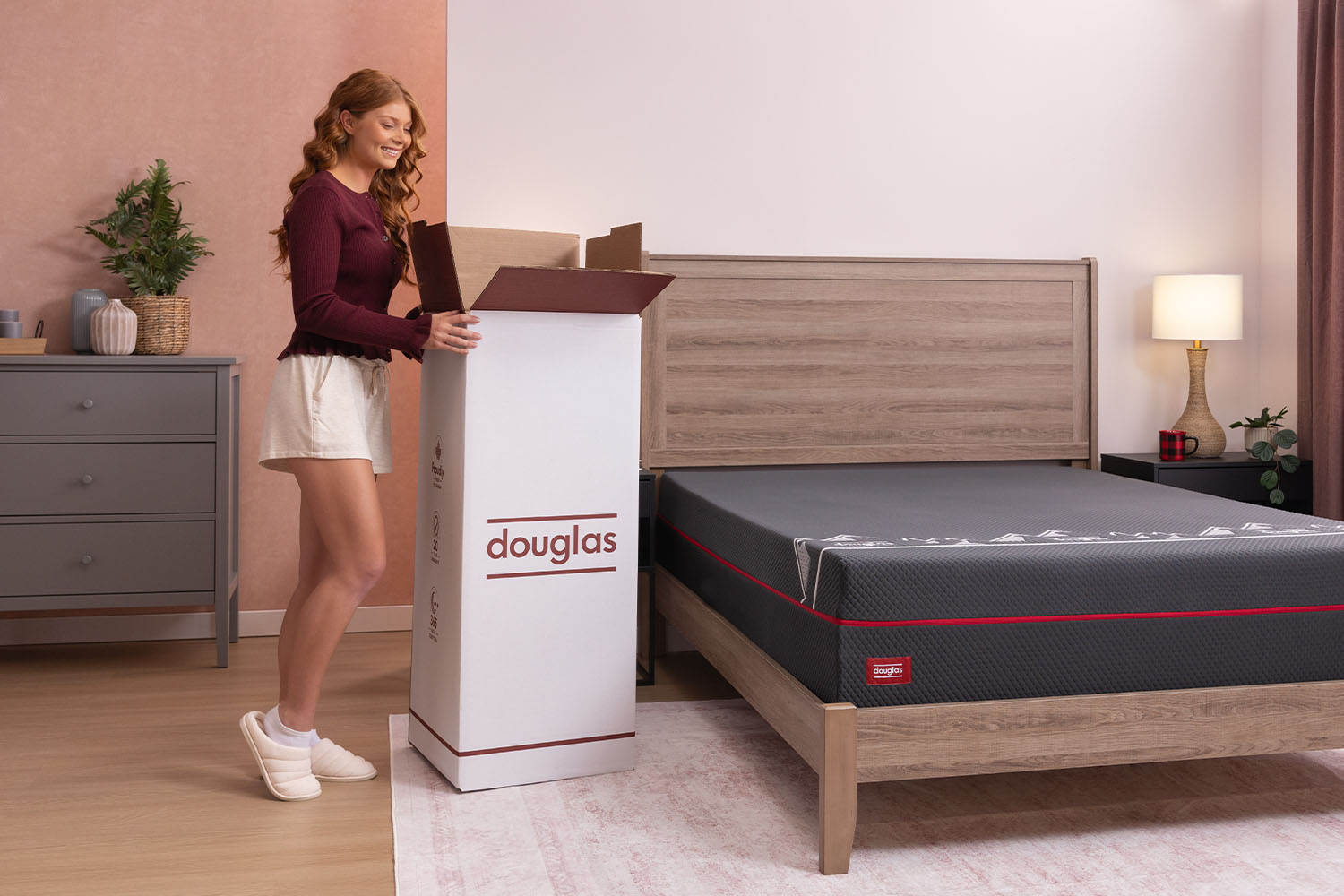 Woman opening the shipping box for her Douglas Summit Hybrid mattress