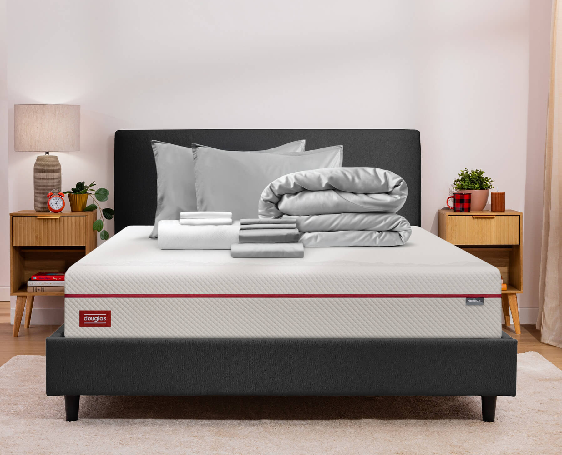 A grey premium sleep bundle sits neatly folded on a Douglas Original Mattress