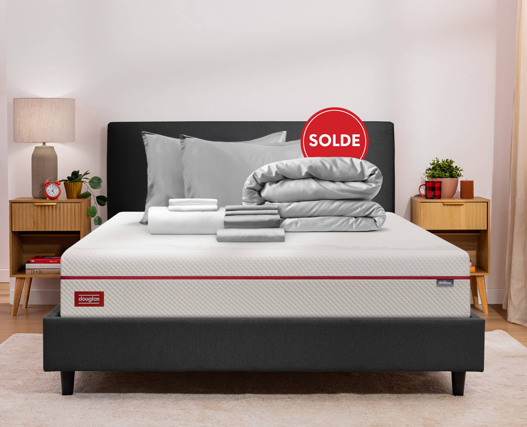 Un Ensemble de sommeil premium gris est soigneusement pli&eacute; sur un matelas Douglas Original.