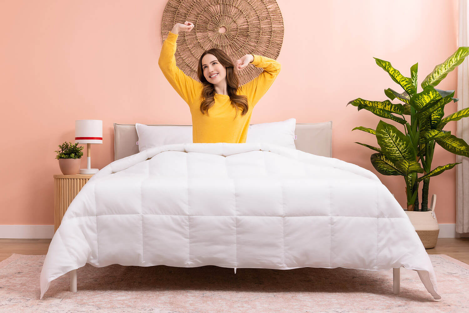 Femme se réveillant dans son lit avec sa couette en duvet synthétique Douglas