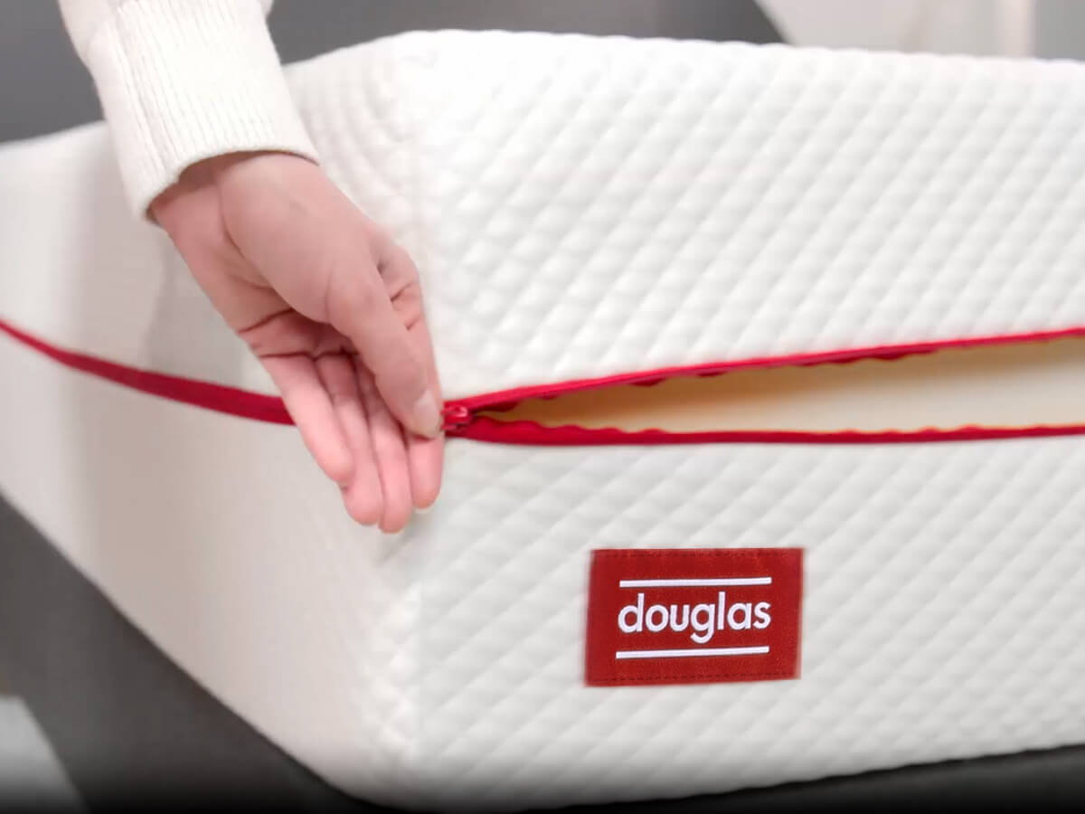 A pristine Douglas mattress cover is being unzipped