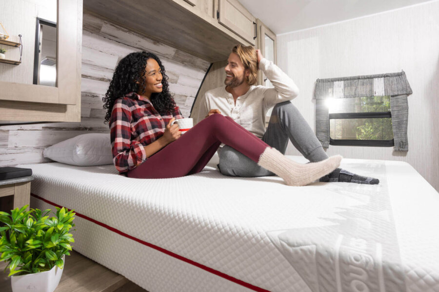 Woman and man sitting on a Douglas Alpine RV mattress