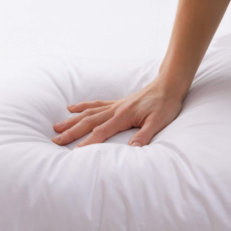 Hand pressing into a Douglas Down Alternative Pillow