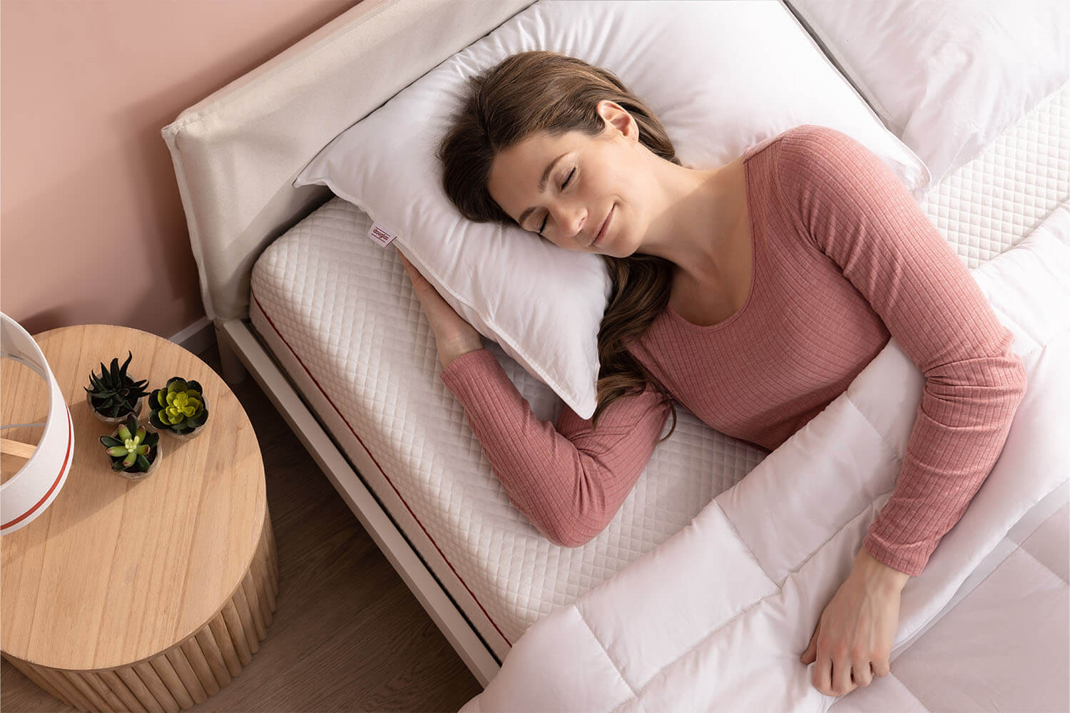 Une femme dort paisiblement sur un oreiller en duvet synthétique Douglas.
