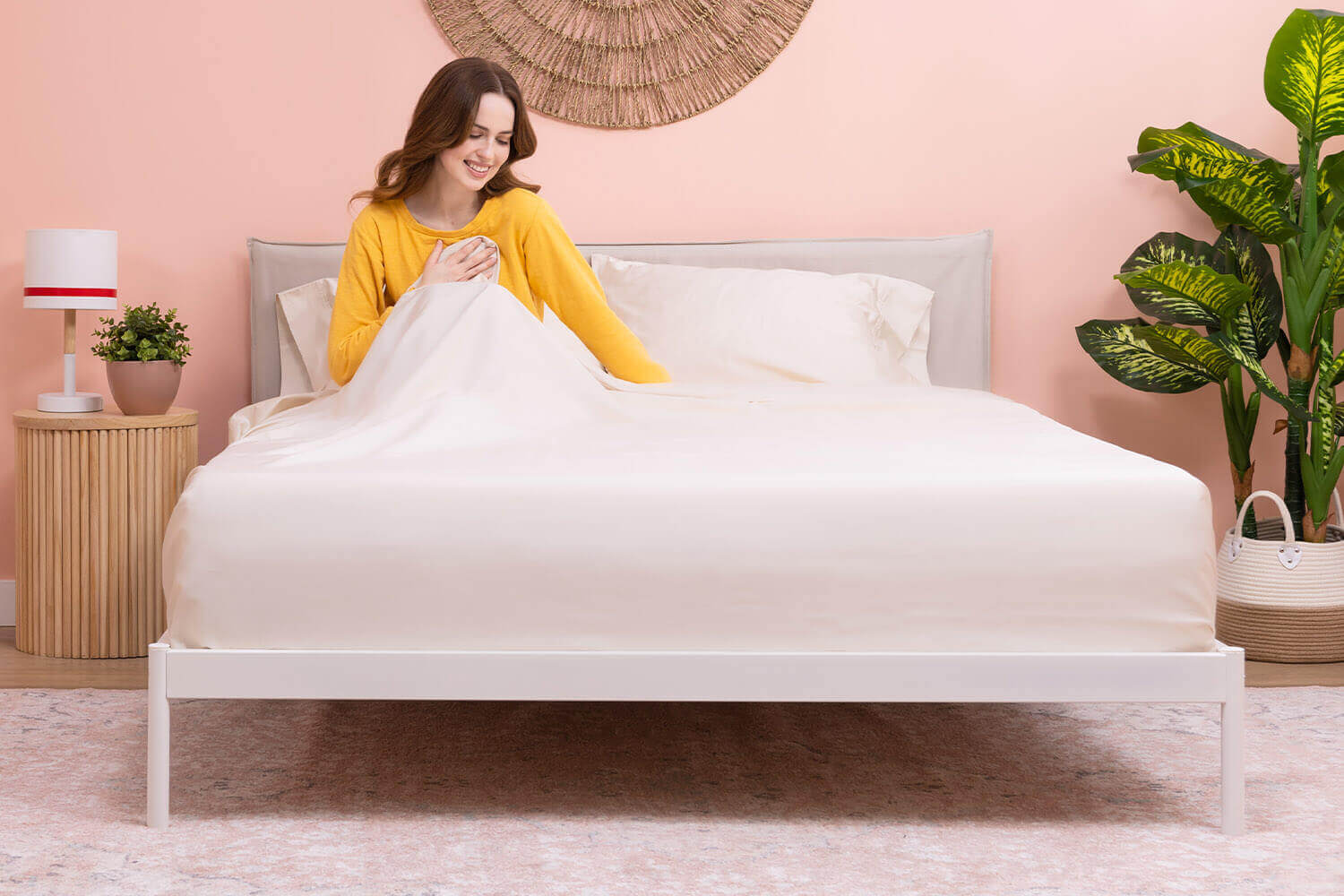 Woman sitting in bed and touching her Douglas Egyptian Cotton Sheets